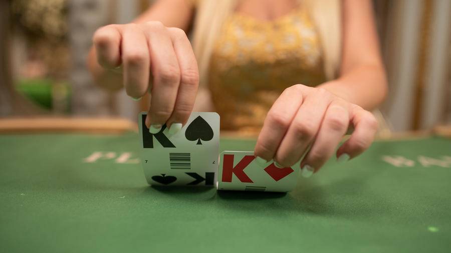 Baccarat dealer flips cards.