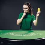 Live casino dealer holds yellow card.
