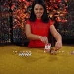 Evolution Gaming dealer placing cards in baccarat