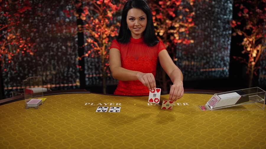 Evolution Gaming dealer placing cards in baccarat