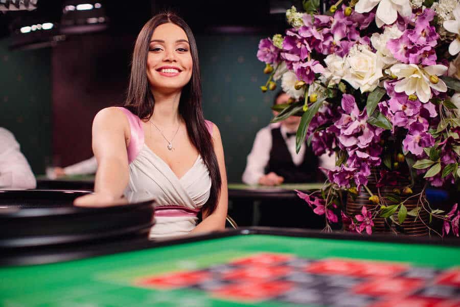 Brunette smiling into the camera next to table